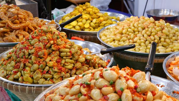 Exotic Oriental Asian sweet delicious desserts, unusual colorful traditional dishes on the counters of a bazar with street food. Evening food court in bangkok, the capital of cooking. Night market