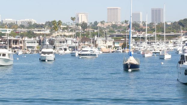 Newport beach harbor, weekend marina resort with yachts and sailboats, Pacific Coast, California, USA. Waterfront luxury suburb real estate in Orange County. Expensive beachfront holiday destination.