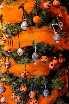 The green Christmas tree is beautifully decorated with toys. Halloween