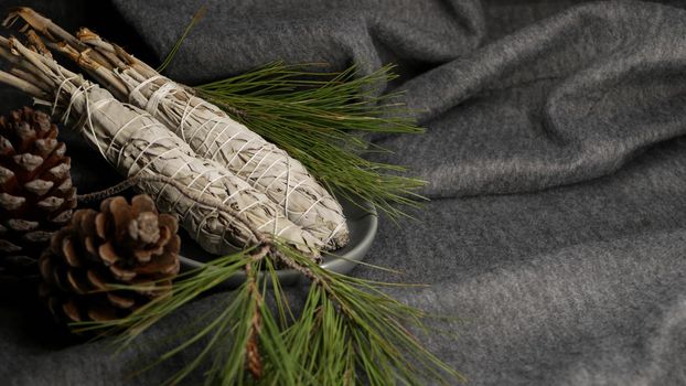 Dried white sage smudge stick, relaxation and aromatherapy. Smudging during psychic occult ceremony, herbal healing, yoga or aura cleaning. Essential incense for esoteric rituals and fortune telling.