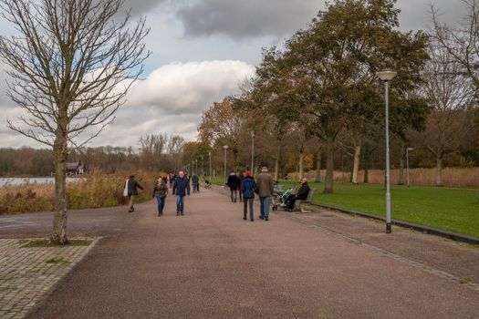 Rotterdam,Holland,11-nov-2020:people running, walking and sitting on a bench during corona time,people asked to stay at home