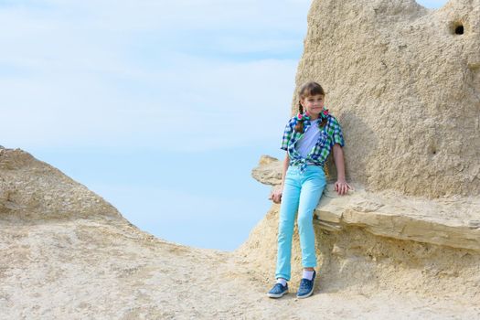 A ten-year-old girl sat down on a rock ledge resting after climbing