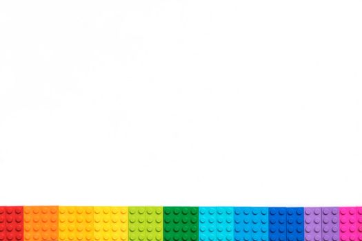 Multicolor Plastick constructor bricks on white background. Popular toys. Copyspace