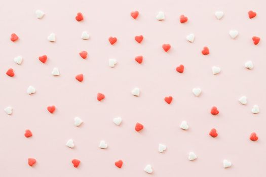Valentine's Day background with red and white little hearts on pink backdrop. Valentines day concept. Copy space. Top view