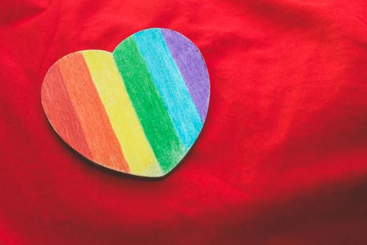 Decorative Heart with rainbow stripes on red background. LGBT pride flag, symbol of lesbian, gay, bisexual, transgender, social movements. Homosexual love, Human rights concept. Copy space.
