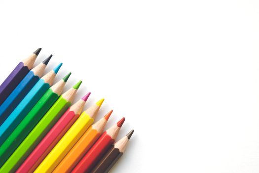 Color pencils on white paper background, copy space. Office supplies, back to school. Top view. Banner