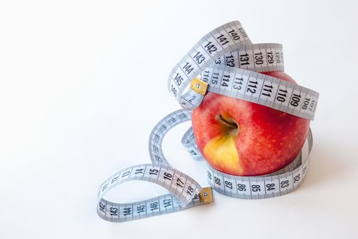 Red Apple and measuring tape on white background. Diet concept