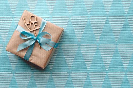 Gift box with blue ribbon on blue background. Freespace