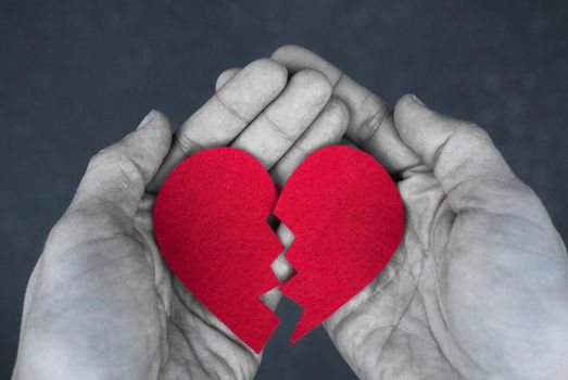 Monochrome photo of Broken red heart in the hands - divorce concept. Blak and white