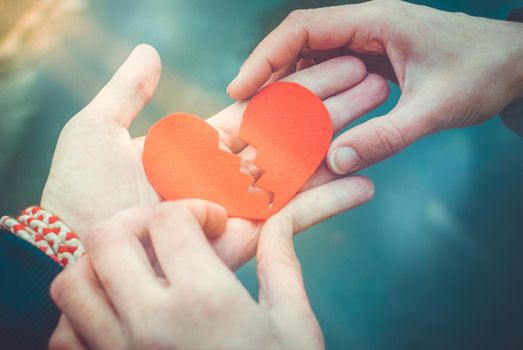 Male and female hands repairing a broken heart. Divorce and Love concept. reunion