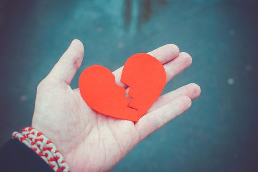 Divorce concept - Broken red heart in the male hands.