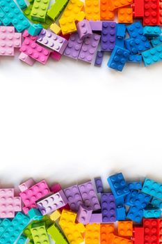 A bunch of Multicolor Plastick constructor bricks on white background. Popular toys. Copyspace