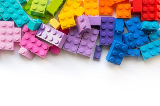 A bunch of Multicolor Plastick constructor bricks on white background. Popular toys. Copyspace