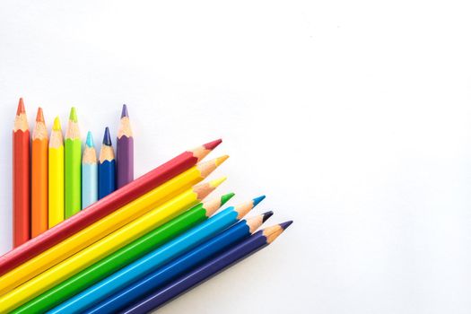 Color pencils on white paper background, copy space. Office supplies, back to school. Top view. Banner