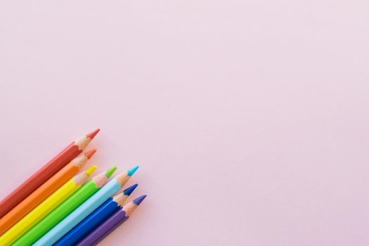 Color pencils on Pink background, copy space. Office supplies, back to school. Top view.