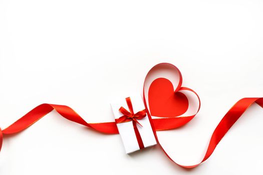 Top view of ribbon shaped as heart and gift box isolated on white background. Valentine's day concept. Copyspace