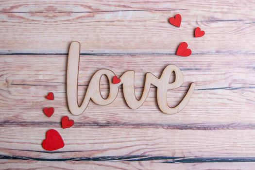 Valentines day card with red hearts on a wooden background with decorative wooden word, love message. Love concept. Romantic. Copyspace