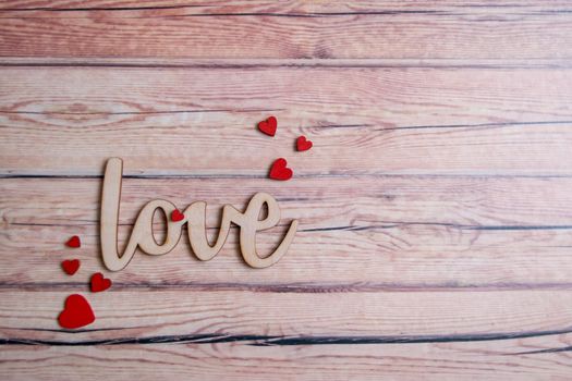 Valentines day card with red hearts on a wooden background with decorative wooden word, love message. Love concept. Romantic. Copyspace