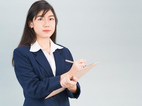 Portrait of Asian woman long hair and wearing suit  with clipboard and pen in hands thinking about success, isolated on white background