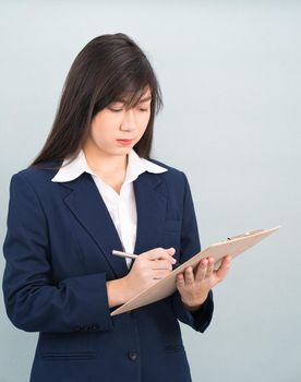 Portrait of Asian woman long hair and wearing suit  with clipboard and pen in hands thinking about success, isolated on white background