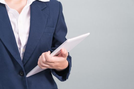 Woman in suit using computer digital tablet isolated on gray background