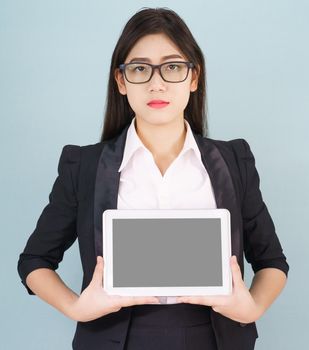 Young asian women in suit holding her digital tablet standing against green background