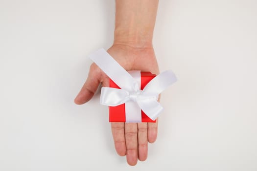 Gift box in men's hands for a holiday. View from above. Flat lay