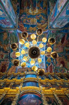 Church of Elijah the Prophet in Yaroslavl 11.07.2019. a high-hanging chandelier on the background of walls with painted icons of saints.