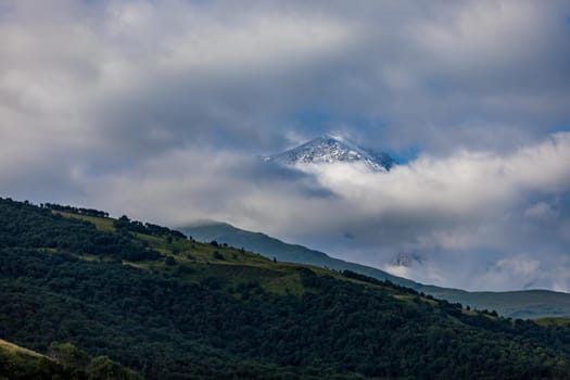 Landscape of the green mountains of the Caucasus thick clouds cover the peaks of the ridge. Fog.