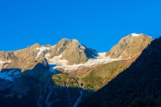 The Caucasus mountains, a glacier on top of the rocks, from the glacier there are three waterfalls. A great fascinating landscape.