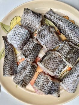 Small raw pieces of lady fish cut into pieces and kept in a plate before cooking