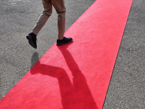 Walking persons on red carpet close view on legs