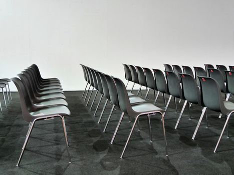 Empty black chairs rows in conference room on white background