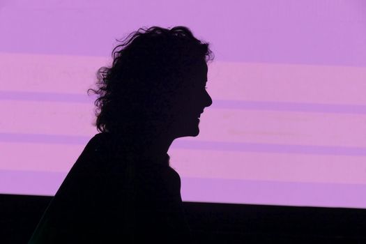 Silhouette of woman talking and gesturing on a pink background