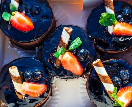 Chocolate mousse cakes decorated with strawberry and chocolate stick.