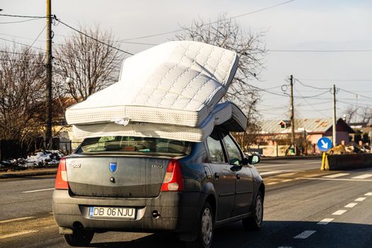 Mattress on car roof, Dacia Logan carrying mattresses on roof in Bucharest, Romania, 2021