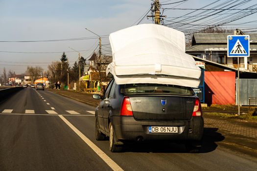 Mattress on car roof, Dacia Logan carrying mattresses on roof in Bucharest, Romania, 2021