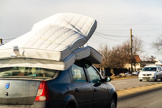 Mattress on car roof, Dacia Logan carrying mattresses on roof in Bucharest, Romania, 2021