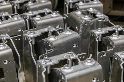 many equal welded aluminium assemblies in factory between tecnological operations, close-up with selective focus