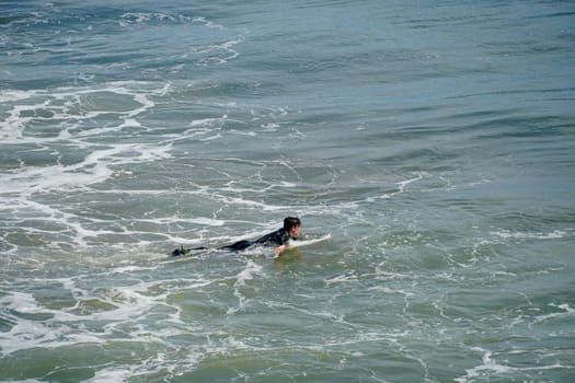 Male surfers enjoying the big wave in Oceanside in North San Diego, California, USA. Travel destination in the South West Coast famous for surfer. January 2n, 2021