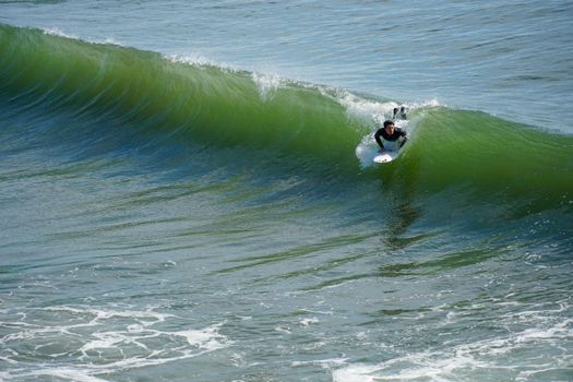 Male surfers enjoying the big wave in Oceanside in North San Diego, California, USA. Travel destination in the South West Coast famous for surfer. January 2n, 2021