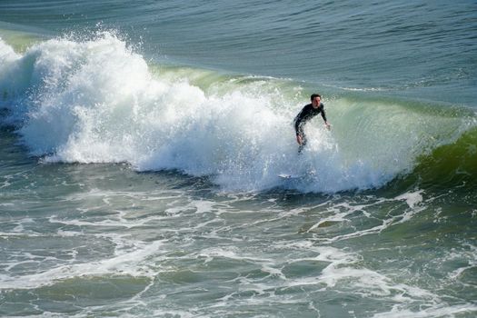 Male surfers enjoying the big wave in Oceanside in North San Diego, California, USA. Travel destination in the South West Coast famous for surfer. January 2n, 2021