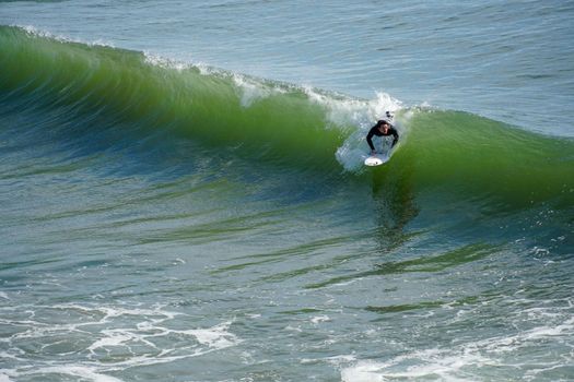 Male surfers enjoying the big wave in Oceanside in North San Diego, California, USA. Travel destination in the South West Coast famous for surfer. January 2n, 2021