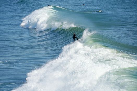 Male surfers enjoying the big wave in Oceanside in North San Diego, California, USA. Travel destination in the South West Coast famous for surfer. January 2n, 2021