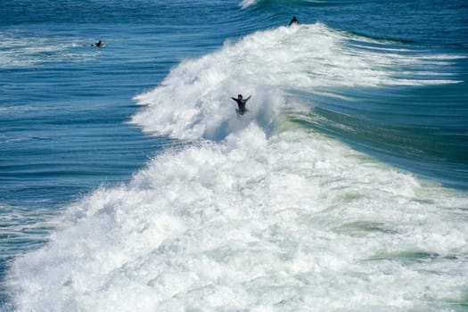 Male surfers enjoying the big wave in Oceanside in North San Diego, California, USA. Travel destination in the South West Coast famous for surfer. January 2n, 2021