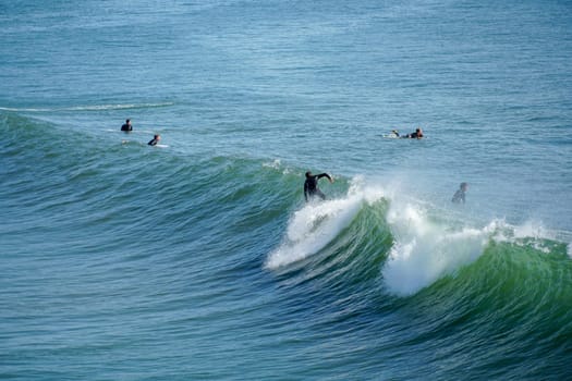 Male surfers enjoying the big wave in Oceanside in North San Diego, California, USA. Travel destination in the South West Coast famous for surfer. January 2n, 2021