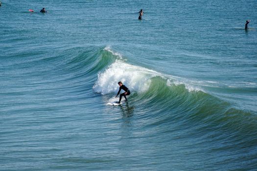 Male surfers enjoying the big wave in Oceanside in North San Diego, California, USA. Travel destination in the South West Coast famous for surfer. January 2n, 2021