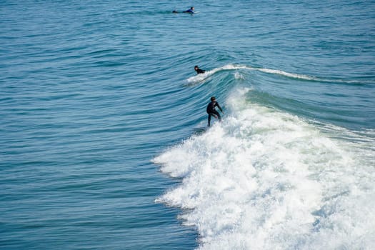 Male surfers enjoying the big wave in Oceanside in North San Diego, California, USA. Travel destination in the South West Coast famous for surfer. January 2n, 2021