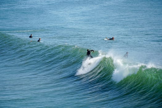 Male surfers enjoying the big wave in Oceanside in North San Diego, California, USA. Travel destination in the South West Coast famous for surfer. January 2n, 2021