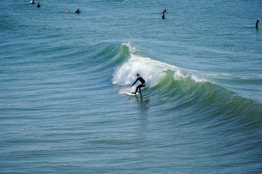 Male surfers enjoying the big wave in Oceanside in North San Diego, California, USA. Travel destination in the South West Coast famous for surfer. January 2n, 2021